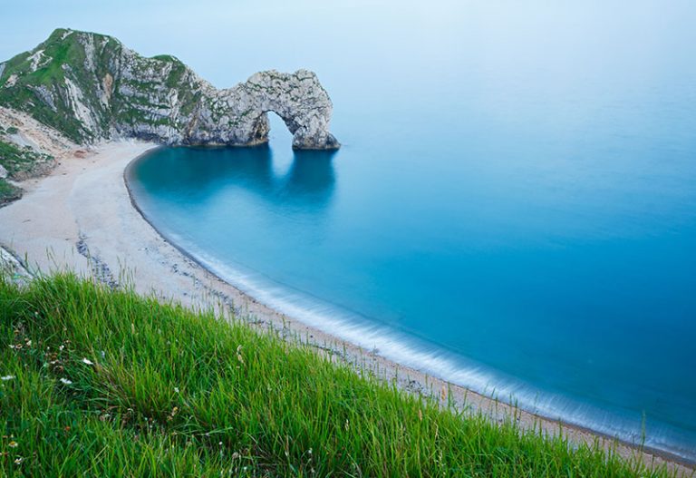 Evening view of Durdle Door beach, Dorset, England. Durdle door is one of the many stunning locations to visit on the Jurassic coast in southern England. Adventures in Britain - UK travel guide